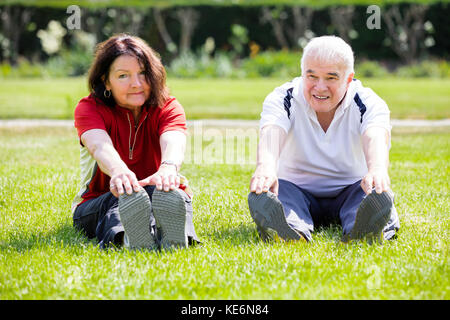 Couple de personnes âgées dans l'exercice d'étirement park Banque D'Images