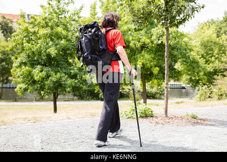 Portrait Of A Happy Senior Female Hiker avec pôle Randonnée Banque D'Images