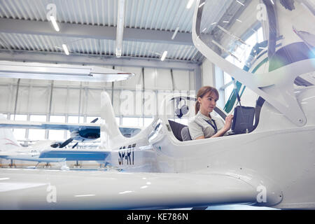 Pilote femelle dans le cockpit du petit avion Banque D'Images