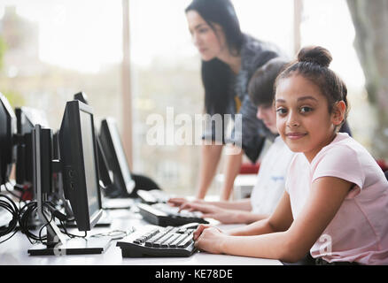 Portrait confiante jeune fille étudiant utilisant l'ordinateur dans la bibliothèque Banque D'Images