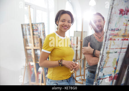 Portrait souriant artistes peindre au chevalet dans un studio de classe d'art Banque D'Images