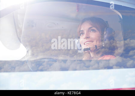 Femme souriante pilote avion dans le cockpit Banque D'Images