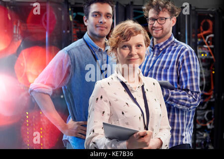 Des techniciens informatiques en toute confiance grâce à une tablette numérique dans la salle des serveurs Banque D'Images