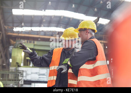 Les hommes parlent en usine Banque D'Images