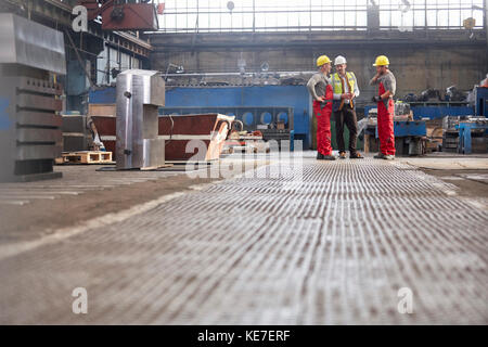 Les hommes parlent en usine Banque D'Images