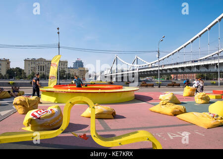 Les gens à jouer au tennis de table dans le Parc Gorky, avec pont Krymsky (pont de Crimée) en arrière-plan, Moscou, Russie. Banque D'Images