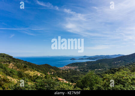 Vue horizontale sur petite ville Marciana Marina, sur la côte de l'île d'Elbe dans la mer méditerranée. les collines et les montagnes autour sont couverts par tre Banque D'Images