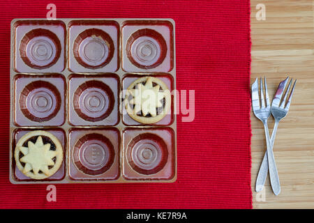 Deux petits pâtés restant dans le bac de 9 trous avec deux fourchettes à Gâteau mis sur le tapis rouge Banque D'Images