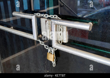 Poignée de porte d'entrée d'un magasin de la chaîne et cadenas fermé avec portes Banque D'Images