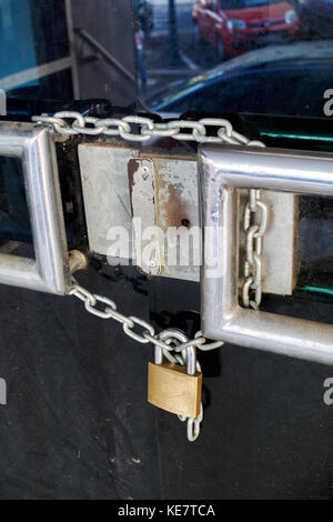 Poignée de porte d'entrée d'un magasin de la chaîne et cadenas fermé avec portes Banque D'Images