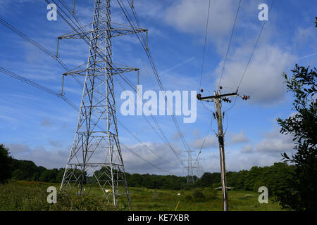 Photos grand angle de l'électricité et les communications téléphoniques pylônes pôle against a blue sky Banque D'Images