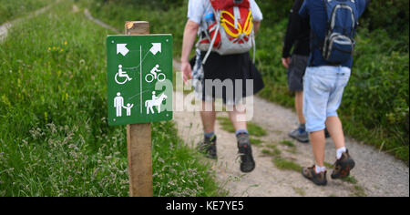 Les promeneurs marchant sur les South Downs Way de Winchester à Eastbourne à côté d'un panneau indiquant les droits d'accès pour les chemins et sentiers pour plusieurs utilisateurs. Banque D'Images