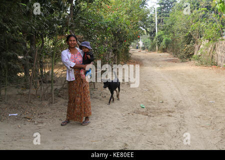 Nyaunghtaw village est sur la gauche (est) de la rivière Irrawaddy dans la province de l'Ayeyarwaddy au Myanmar (Birmanie). femme et enfant de chien avec stree. Banque D'Images