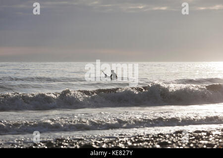 Retour Allumé Surfer assis sur une planche de surf dans la région de Kachemak Bay, Homer, Southcentral Alaska, USA Banque D'Images