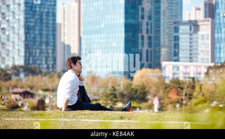 Vue latérale du businessman prendre du repos à l'extérieur pendant la journée Banque D'Images