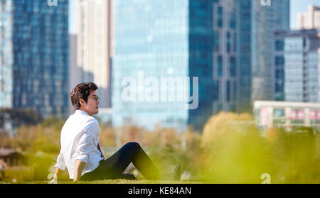 Vue latérale du businessman prendre du repos à l'extérieur pendant la journée Banque D'Images