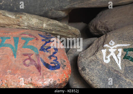 Des pierres avec le Mantra bouddhiste om mani écrit en sanskrit, padmehum au Tibet. Banque D'Images