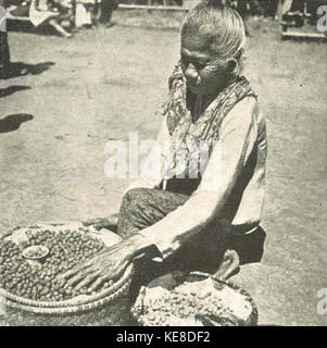 Une femme vendant des arachides à Garut, Indonésie. Capturée dans une photo détaillée, l’image souligne son rôle dans l’économie locale, proposant des arachides à la vente en milieu rural. Banque D'Images