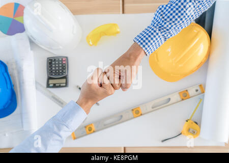 L'équipe d'Asie ou d'affaires ingénieur et architectes partenaires donnant fist bump après accord complet. d'équipe réussi partenariat dans un bureau. businessma Banque D'Images