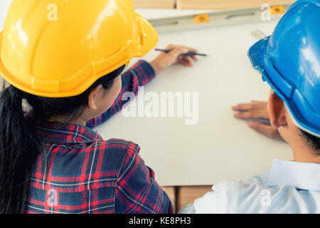 Couple de jeunes ingénieurs ou d'architectes travaillant dans le bureau. Les ingénieurs ou architectes et séance de planification projet. Vue de dessus Banque D'Images