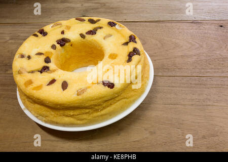 Gâteau en coton, mélange de fruits d'amande, noix de cajou, canneberges, mangues séchées, raisins secs verts, sur plaque blanche, prêt à manger, sur table en bois rustique Banque D'Images