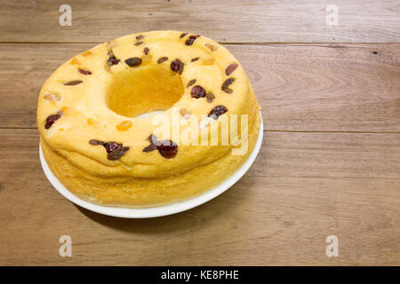 Gâteau en coton, mélange de fruits d'amande, noix de cajou, canneberges, mangues séchées, raisins secs verts, sur plaque blanche, prêt à manger, sur table en bois rustique Banque D'Images