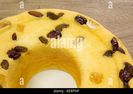 Gâteau en coton, mélange de fruits d'amande, noix de cajou, canneberges, mangues séchées, raisins secs verts, sur plaque blanche, prêt à manger, sur table en bois rustique Banque D'Images