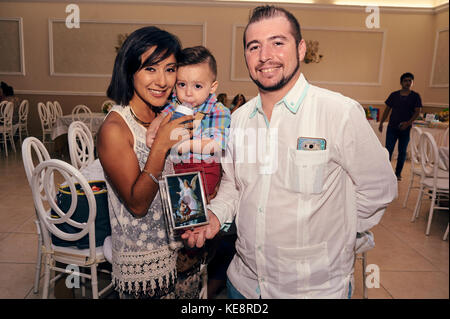 Couple avec bébé dans les bras tenant le baptême party favor Banque D'Images