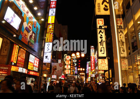 La foule et lumineux dans la nuit. Les gens d'Osaka, qui sont les habitants et les touristes, affluent autour de la zone commerçante d'Osaka. Non loin de la célèbre icône Banque D'Images