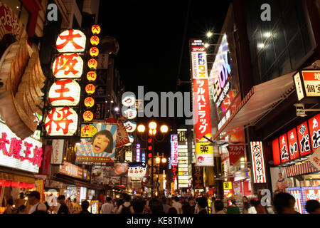 La foule et lumineux dans la nuit. Les gens d'Osaka, qui sont les habitants et les touristes, affluent autour de la zone commerçante d'Osaka. Non loin de la célèbre icône Banque D'Images