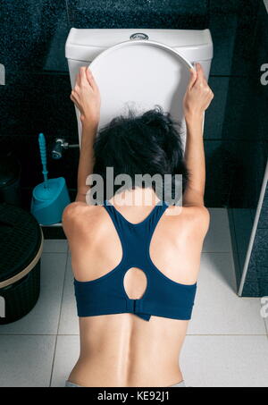 Femme malade dans les toilettes d'accueil Banque D'Images