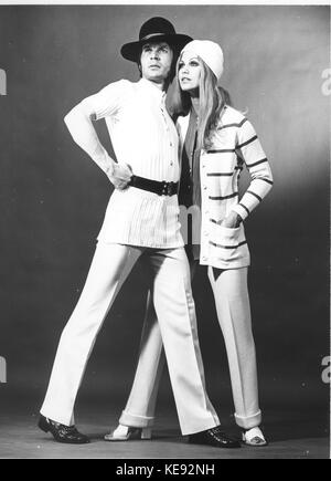 Un mannequin masculin (l) porte une longue chemise en coton avec une ceinture. La mannequin (R) porte une veste rayée et les deux portent un pantalon avec pli, photographié le 9 novembre 1970. | utilisation dans le monde entier Banque D'Images