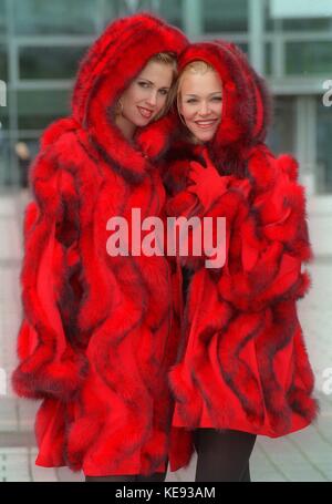 Deux jeunes femmes portent des manteaux de fourrure rouge au salon de la mode à Francfort (Hesse, Allemagne) le 14 avril 1999. | utilisation dans le monde entier Banque D'Images