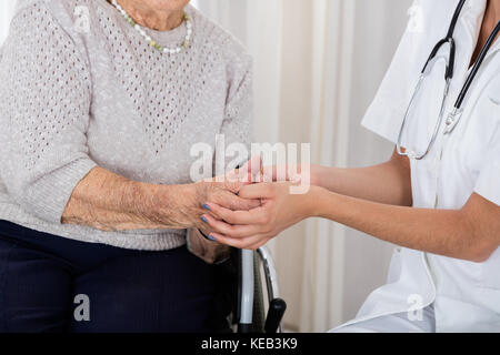 Portrait de femme médecin handicapés consolant senior patient in hospital Banque D'Images