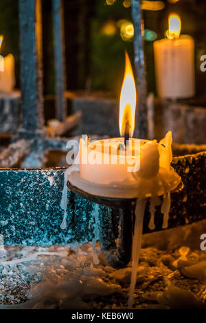 Lueur des bougies dans un sombre dans l'église. Spiritualité, maison de concept. bougies dans l'obscurité, la cire fondue, vieux chandelier. Banque D'Images