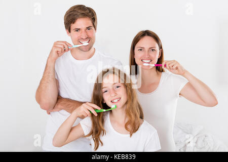 Parent avec leur fille se brosser les dents ensemble Banque D'Images