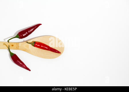 Faisceau de piment rouge et cuillère en bois sur fond blanc Banque D'Images