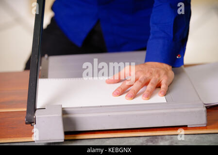 Close up of hand homme sur la guillotine, travaillant sur la guillotine, papier de coupe Banque D'Images