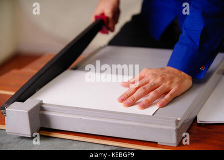 Close up of hand homme sur la guillotine, travaillant sur la guillotine, papier de coupe Banque D'Images