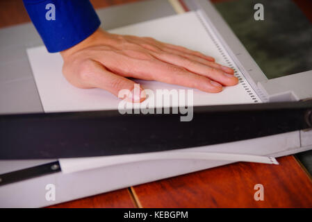 Close up of hand homme sur la guillotine, travaillant sur la guillotine, papier de coupe Banque D'Images