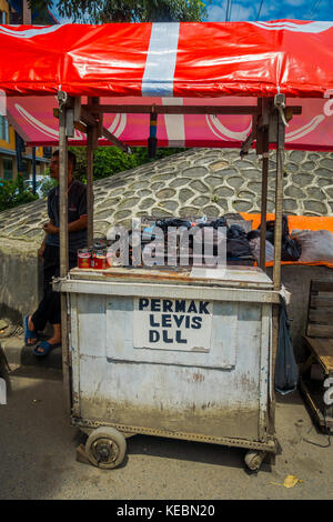 Jakarta, Indonésie - 3 mars, 2017 : local homme debout à côté de son chariot de petites entreprises, offrant des petites réparations Banque D'Images