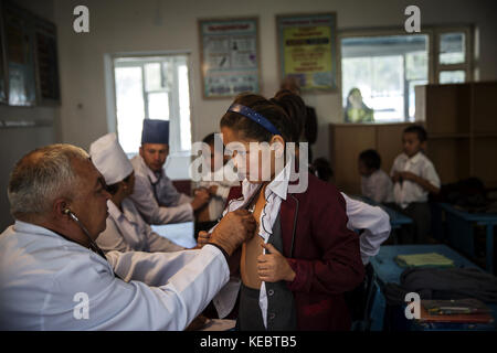 Beshkent, Kirghizistan. 11 octobre 2016. Une équipe médicale visite une école primaire à Beshkent, au Kirghizistan, où presque tous les villageois recueillent de l’eau dans l’arcade, un canal d’irrigation ou directement dans une rivière. L'eau potable est vulnérable à la contamination par les bactéries qui causent l'hépatite et d'autres maladies d'origine hydrique. Les habitants espèrent et planifient un projet d'infrastructure pour apporter de l'eau potable à leurs maisons. Dans les villages du Kirghizistan (Asie centrale), les systèmes et infrastructures obsolètes d'approvisionnement en eau sont à l'origine de problèmes de santé tels que les épidémies d'hépatite et de gastroint Banque D'Images