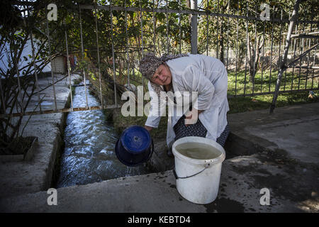 Beshkent, au Kirghizistan. 11Th oct 2016. nosirova anabar qui est employé en tant que travailleur de la cuisine à l'école beshkent rassemble 80 à 100 litres d'eau chaque après-midi. Elle filtre l'eau par coton fromage et puis il permet de s'asseoir la nuit de sorte que la poussière se dépose au fond. Elle fait bouillir l'eau avant de prendre le thé pour les étudiants. dans les villages à travers le Kirghizistan (Asie centrale) les systèmes de distribution d'eau vétustes et de l'infrastructure est la cause de problèmes de santé tels que des éclosions d'hépatite et de maladies gastro-intestinales, en particulier chez les enfants. crédit : Jodi hilton/sopa/zuma/Alamy fil live news Banque D'Images