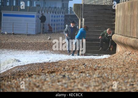 Hastings, East Sussex, UK. 20 octobre 2017. Très ensoleillée, avec rafales de vent, les conditions de vitesse 25km/h et des rafales allant jusqu'à 41 mph. Ce couple malchanceux se font attraper dehors par la mer déchaînée. Prévision est pour un temps orageux pour la fin de semaine. Crédit photo : Paul Lawrenson /Alamy Live News Banque D'Images