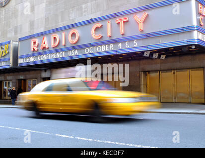 A New York city cab durs passé le Radio City building Banque D'Images