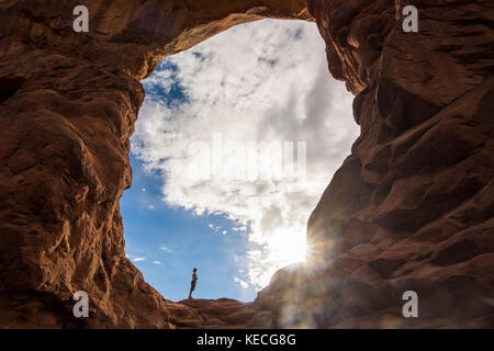 En femme debout dans la tourelle du rétroéclairage arch dans le Arches national park, Utah, USA Banque D'Images