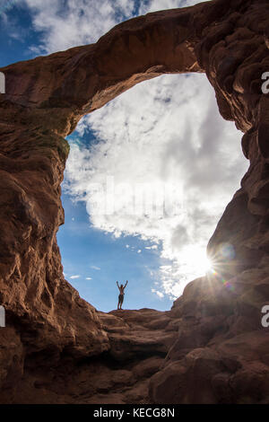 En femme debout dans la tourelle du rétroéclairage arch dans le Arches national park, Utah, USA Banque D'Images