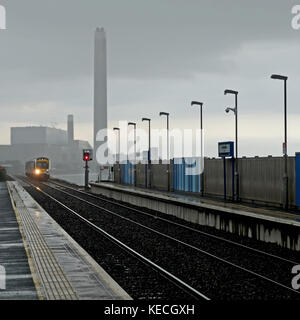 Train approchant Downshire sous la pluie, avec la centrale électrique de Killoot en arrière-plan. Banque D'Images