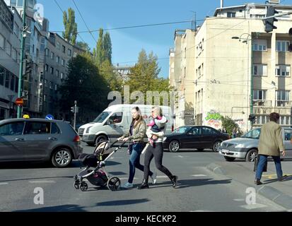 Deux femmes crossing street avec poussette de bébé sur feu de circulation Banque D'Images