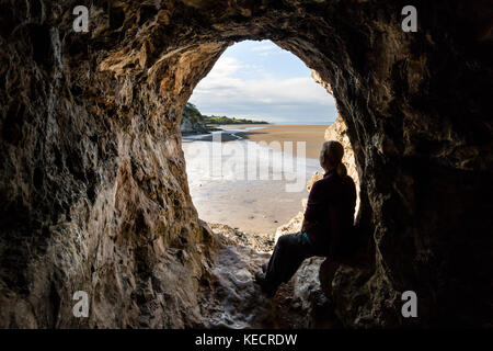 Walker en profitant de la vue de l'intérieur de l'ensemble de la grotte Cove Sands de la baie de Morecambe, Silverdale, Lancashire, UK Banque D'Images